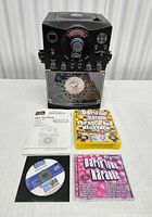 karaoke unit with manual, CD packs, loose disc on table