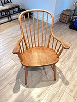 Front view showing sculpted seat, spindle back, arms, turned legs