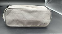 Front view of Dior quilted cosmetic bag showing logo and cannage pattern