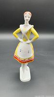 Full front view of porcelain folk dancer figurine on base
