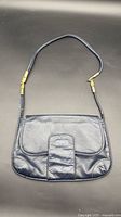 Full view of navy leather shoulder bag with strap extended