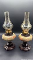 Front view of both matching ceramic oil lamps showing overall design and condition