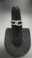 Front view of sterling silver infinity knot ring on display stand