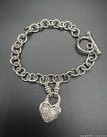 Full view of sterling silver roped link bracelet with toggle clasp and diamond heart charm