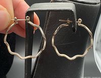 Pair of zig-zag hoop earrings on display stand