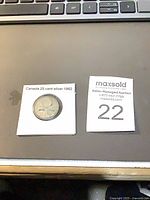 Coin in holder beside lot number card