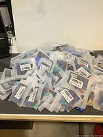 Pile of individually packaged Bike Bits valve adapters/caps on tabletop