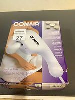 Front of retail box displaying Conair Touch & Tone massager and attachment images