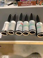 Six Laundry Essentials lint rollers laid out showing labels and handles