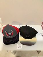 Front view of both caps showing logos and visors