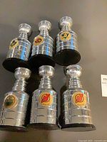 All six miniature Stanley Cup trophies displayed upright