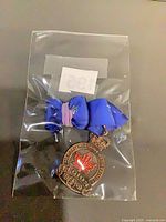 Medal in plastic bag showing obverse maple leaf and ribbon