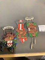 Front view of all three medals showing designs and dangles
