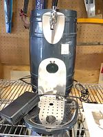 Front view of beer dispenser with tap, drip tray, power adapter, manual visible