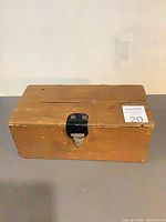 Top view of wooden money box showing coin slot and metal latch