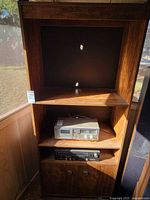 Full view of tall wood-finish media shelf with stereo gear shown but not included