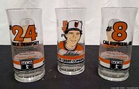Front view of three Orioles pint glasses showing Rick Dempsey, Cal Ripken Jr.