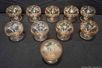 All ten amber-tinted stemmed liquor glasses arranged in two rows