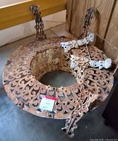 Upside-down view of entire cast iron bench showing broken legs and rust