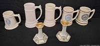 Front view of all five steins and two candle holders