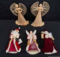Group shot showing five toppers: straw angels in back, three fabric figures in front