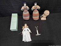 Overview of all items: two cloth dolls, Cinderella doll, stand, box, ceramic figurine