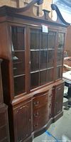 Full view of china cabinet showing glass doors, drawers, cupboards, and carved crown
