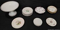 Full lot showing pedestal compote, stacked plates, single plates and bowl