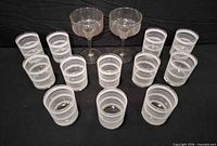 Full lot showing 12 striped tumblers arranged in rows and 2 stem coupes behind them