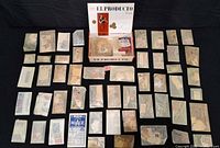 Top-down view of cigar box and numerous glassine envelopes filled with stamps