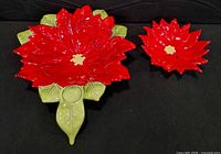 Large and small poinsettia-shaped ceramic dishes side by side