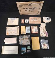 Entire lot laid out showing supplement envelope, album pages, multiple stamp packets, envelopes and loose stamps