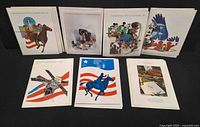 All seven USPS commemorative stamp folders front covers visible