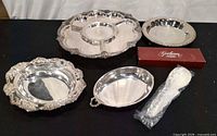 All six pieces displayed: four trays, boxed utensil, sealed spoon
