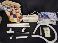 Full lot showing vacuum, attachments, hose, wands, bag of vacuum bags, cloth tote