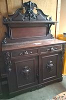 Full front view showing crest, drawers, doors