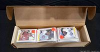 open cardboard long box filled with baseball cards in sleeves