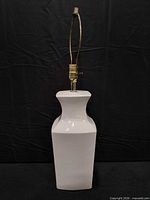 Front view of white ceramic table lamp showing shape and hardware
