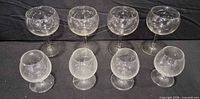All eight etched stemmed glasses arranged in two rows