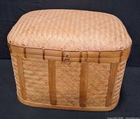 Front view of woven wood basket showing latch and weave pattern