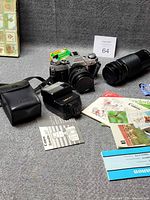 All items laid out: camera with 50 mm lens, flash, pouch, 200 mm lens, manuals, batteries