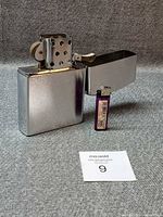 Front view of jumbo chrome lighter open with scale lighter beside
