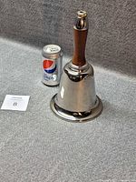 Full view of bell-shaped cocktail shaker beside soda can for scale
