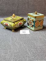 Two decorative tins side by side showing overall form and decoration