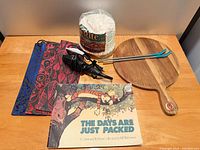 Lot overview showing book, cheese board, curling iron, straws, bags, filters