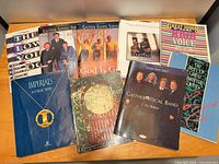 Front covers of nine Christian songbooks laid out on table