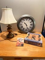 Lamp, wall clock, boxed hot stone massage kit on tabletop