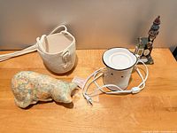 All three items on tabletop: rope planter, floral decoupage cat, white enamel wax melter