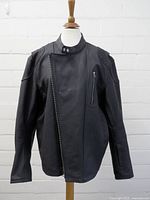 Front view of black Altimate jacket showing asymmetric zipper and chest pocket