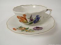 Cup and saucer overview showing floral decoration and gilt trim